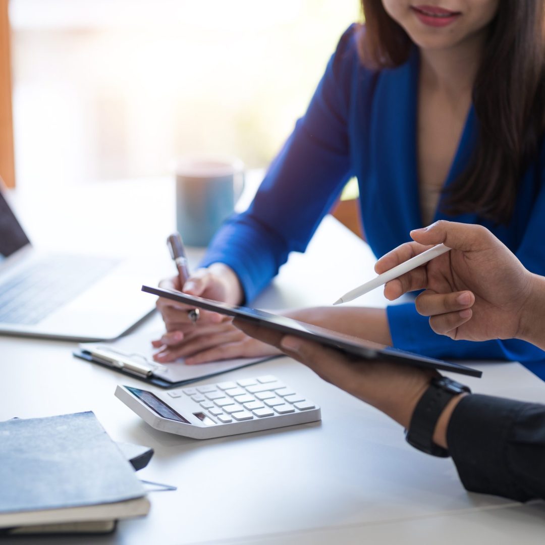 Close-up of businesspeople meeting group to discuss plans Think through graphs and charts. and calculate company performance, balance sheet, finance, income statement during the quarter.