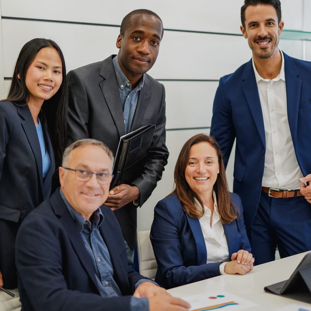 Multiracial business people smiling on camera inside modern office